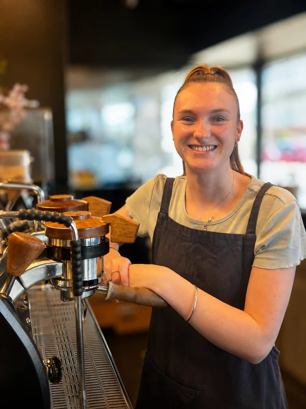 A smiling Native barista at the coffee machine