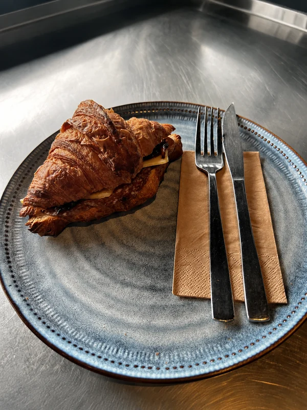 A filled croissant served on a blue plate